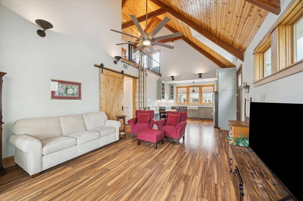Step inside the pool house and be greeted by a beach-inspired interior, featuring a vaulted wood ceiling, expansive windows that invite natural light, and stunning wood flooring.