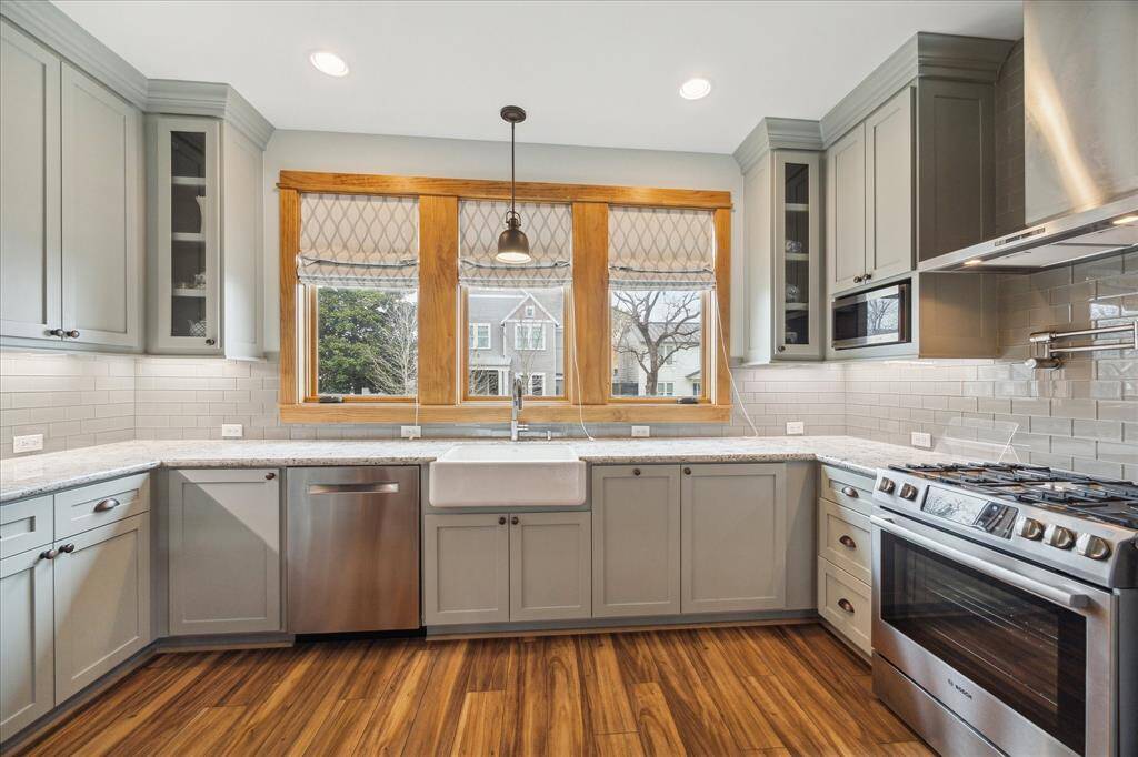 The full kitchen in the pool house is equipped with a gas range, dishwasher, full-size refrigerator/freezer, a large farm sink, and beautiful subway tile backsplash.