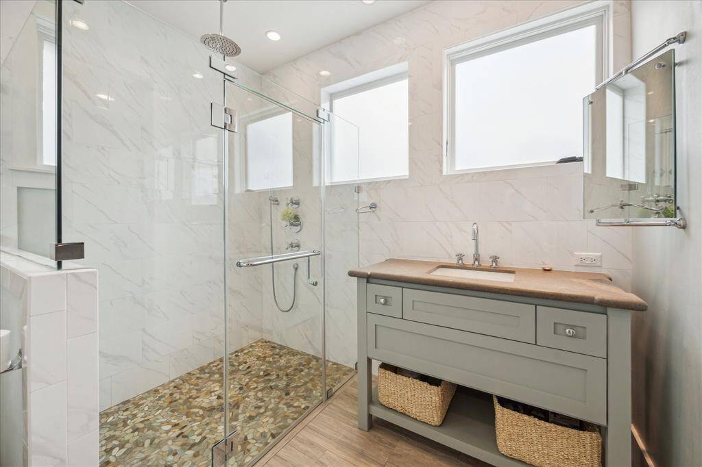The full bath in the pool house features a large frameless shower and a convenient door providing guests with direct access from the pool.