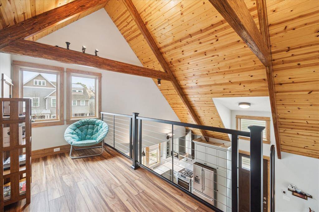 Check out this fantastic loft! With ladder access, this unique space is truly a treat. Featuring iron railing, wood flooring, and a beautiful wood ceiling.