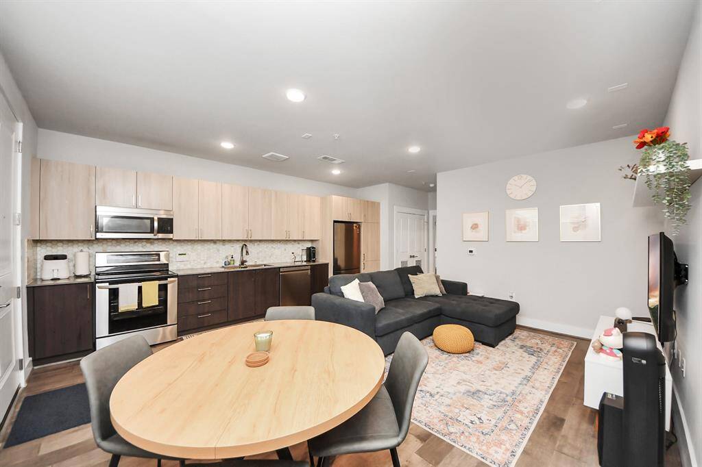 This photo showcases a modern open-concept living space with a kitchen and living room.