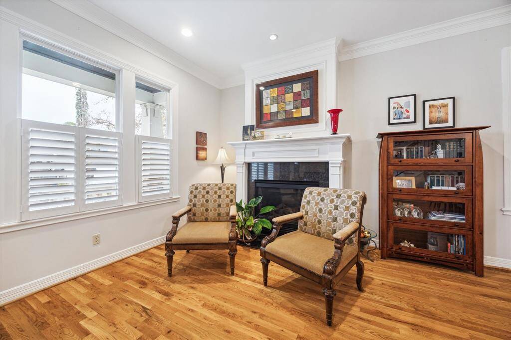 The living room boasts stunning crown molding that beautifully complements the elegant gas fireplace with a classic wood mantle, adding a touch of warmth and sophistication to the space.