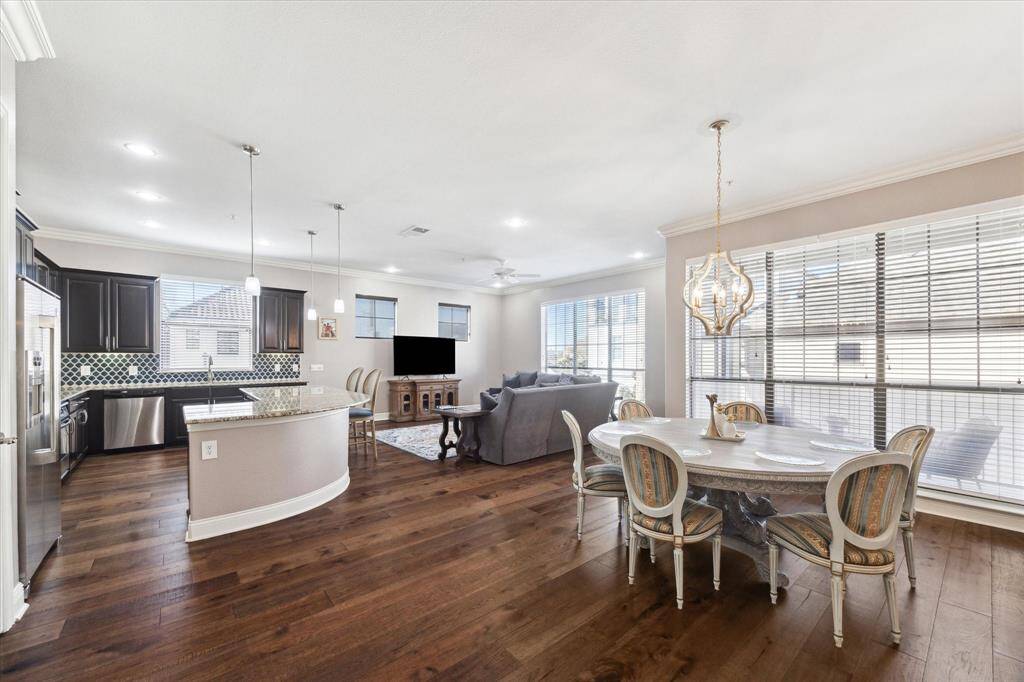 Alternate view of the open layout showcasing the plentiful windows, a dedicated dining area, and a beautiful kitchen with a vibrant backsplash.
