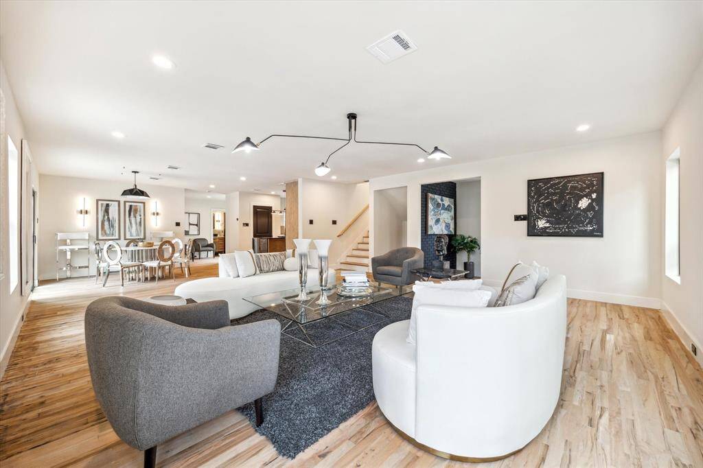 Wet-sanded, natural-hewn wood floors play off of honey colored-custom wood cabinetry while stark white walls and black accents combine with natural light to evoke the passage of a day and a night.
