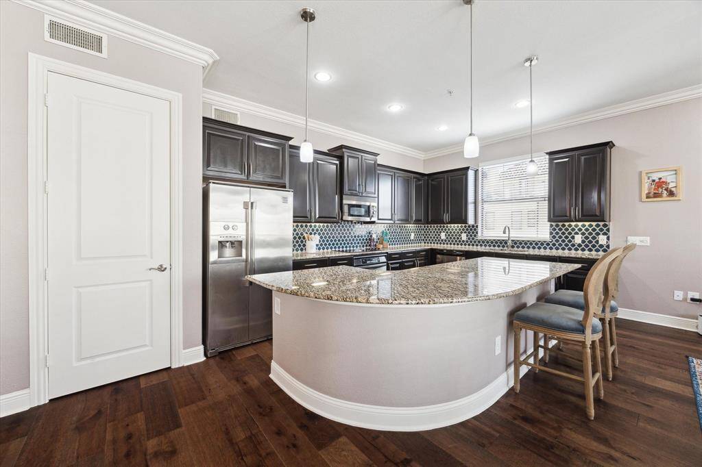 Impressive Kitchen showcasing luxurious granite countertops, an expansive island, a dedicated pantry, and abundant counter and storage space.