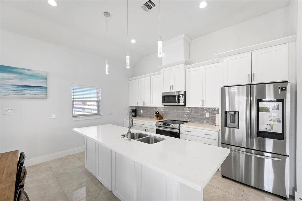 This beautifully designed kitchen not only features quartz countertops and stainless steel appliances but also offers extra cabinet space in the island, providing ample storage for all your kitchen essentials. The open layout ensures effortless flow between cooking, dining, and entertaining.