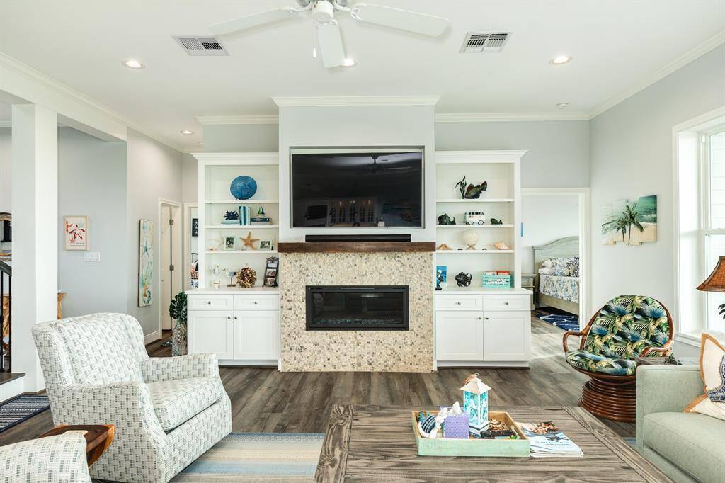 Tasteful gas log fireplace with a stacked stone surround and wood mantle add to the coastal feel of the home.