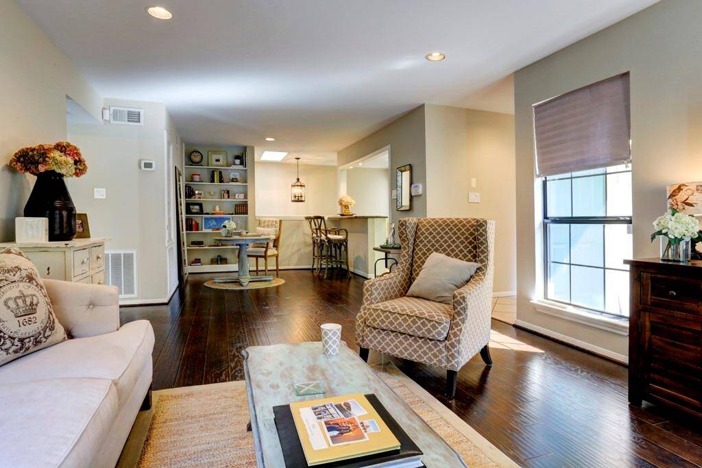 The Primary bathroom features a marble countertop, a large mirror, and ample cabinet space. It connects to a tiled shower with a sliding glass door, providing a clean and functional layout.
