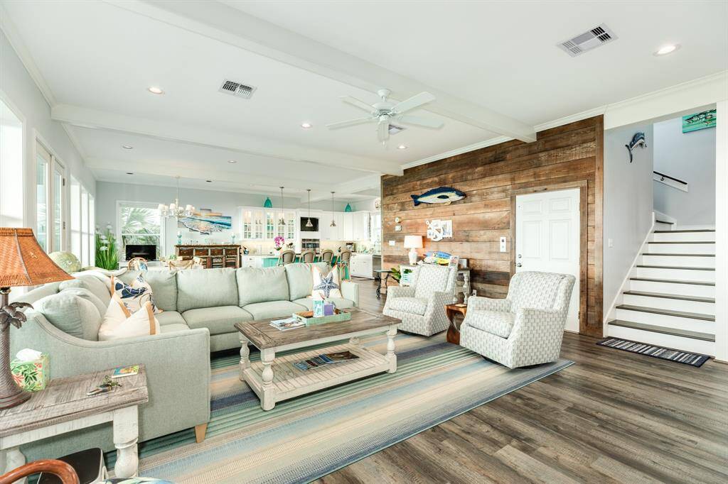 An interior wall in the living area was finished out with reclaimed lumber. This also adds a nice natural & coastal feel to the ambiance of the home. The closed door in view is to the residential service elevation, which services from ground, 1st & 2nd level of home.