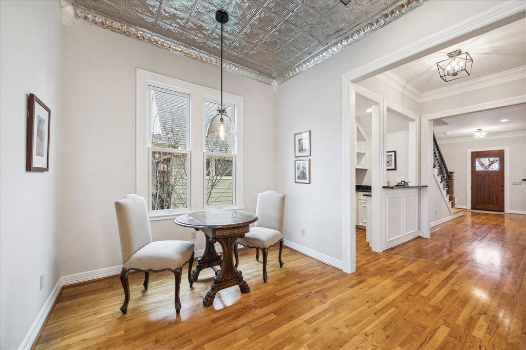 Just past the wet bar, as you enter the kitchen, you'll find a charming breakfast nook featuring pendant lighting and a large window that offers serene views of the pool, creating an ideal spot to enjoy your morning coffee.
