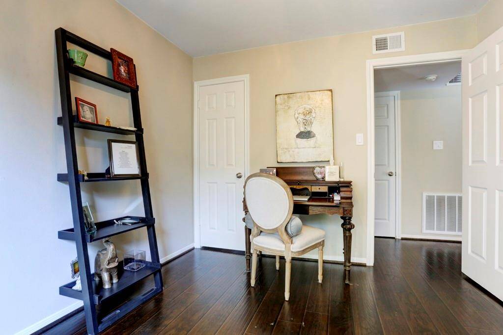 The secondary bathroom features a modern design with a light color scheme. It includes a vanity with ample storage, a large mirror, and a window providing natural light. The shower area is a tub and shower combo.