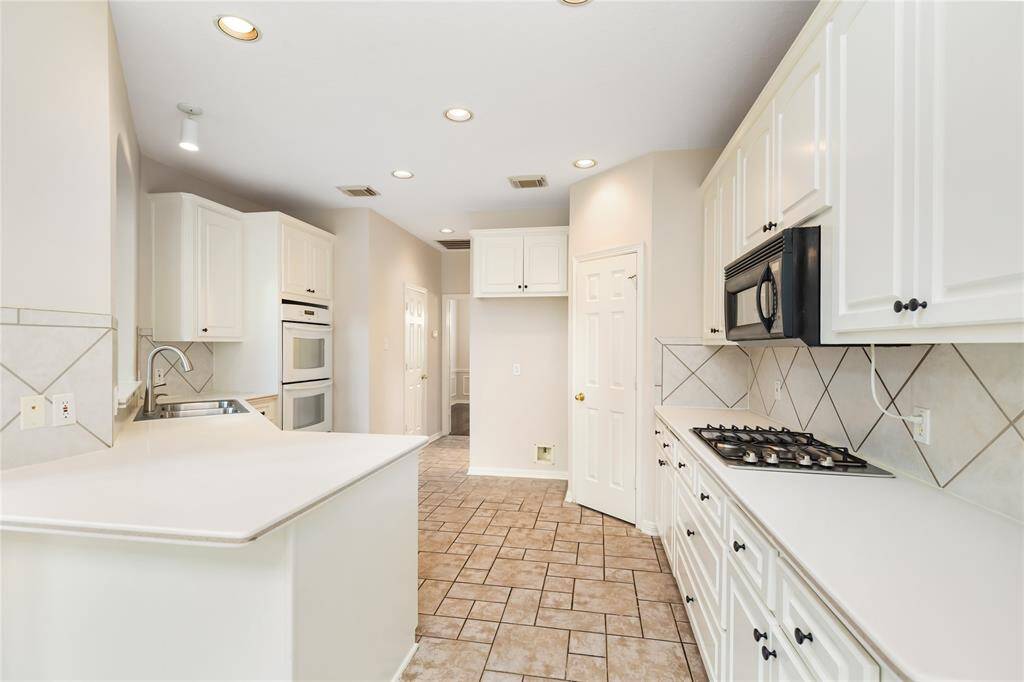 The Kitchen offers a gas cooktop, double ovens, and breakfast bar, along with ample storage and counter space