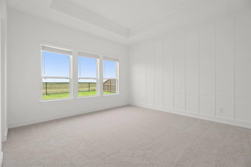 Sun-lit primary suite with feature wall