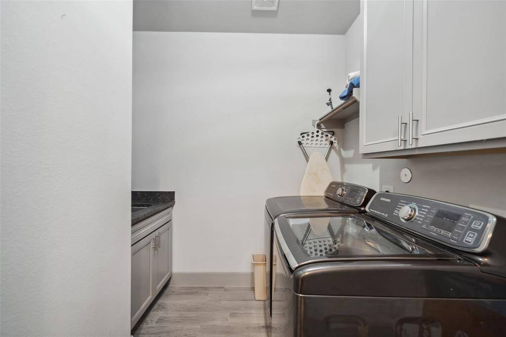 Generously sized laundry room with room for a fridge and there is a sink too!