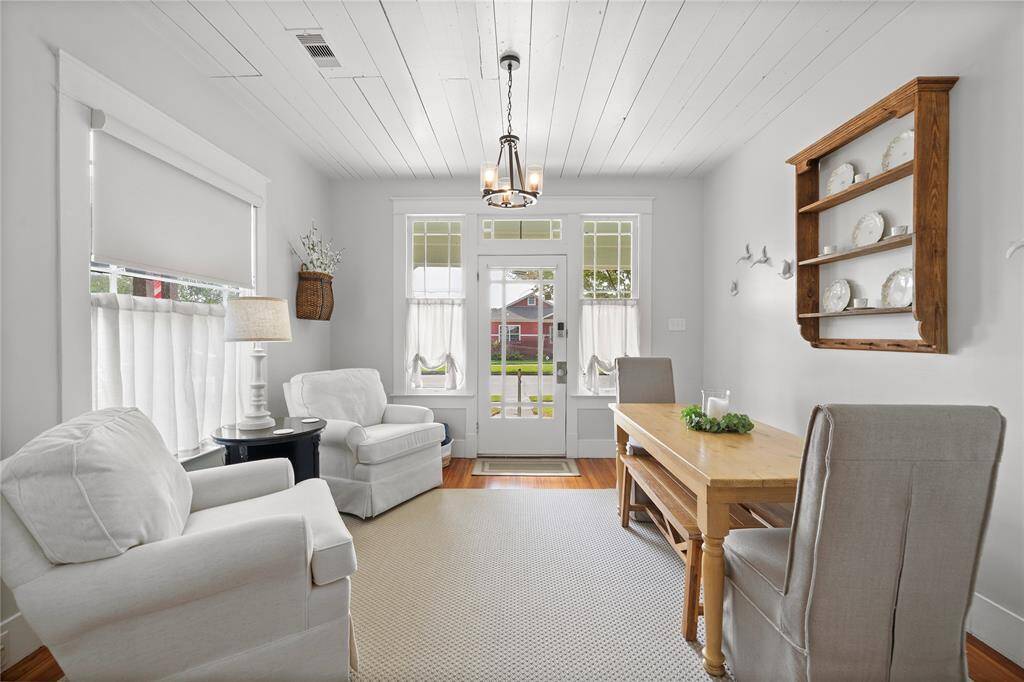 Light filled space with original windows, front door, and ship lap ceiling.