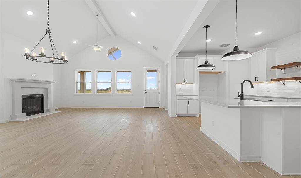 Stunning great room and dining area with fireplace and vaulted ceilings (*Photo not of actual home and used for illustration purposes only.)