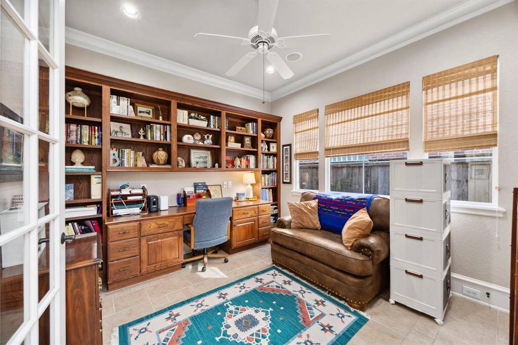 The office features built in shelving and French doors.