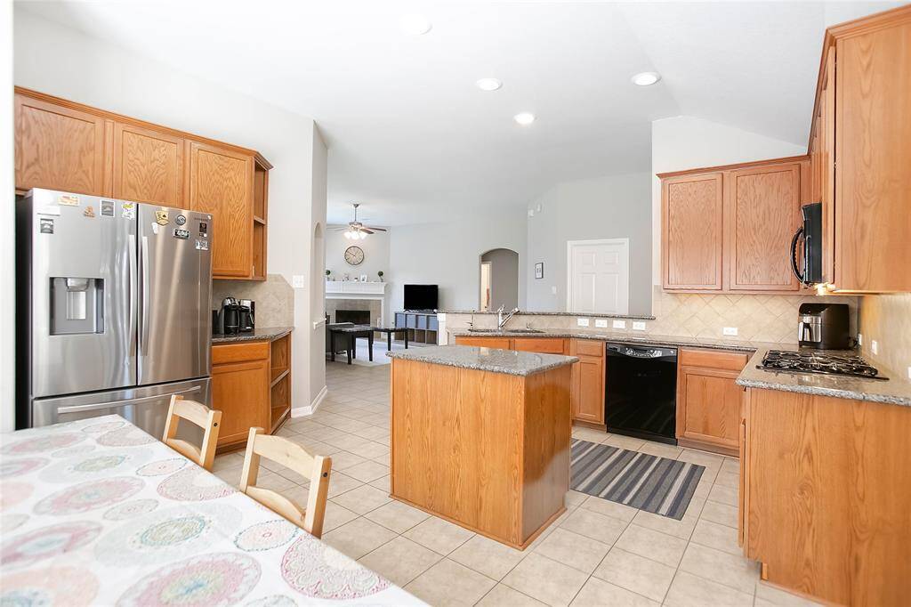 The island kitchen is a chef’s dream, offering granite countertops and sleek stainless steel appliances.