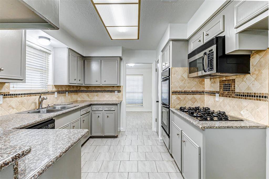 Additional highlights include a gas cooktop with a built-in microwave above, and double ovens, offering both convenience and efficiency for your cooking needs.