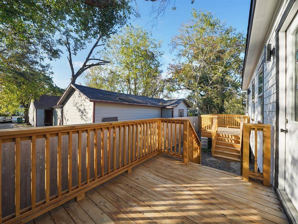 Private deck off the main bedroom in Unit A, featuring a natural wood finish and overlooking the neighboring property. Unit B offers the same beautiful deck for a seamless living experience.