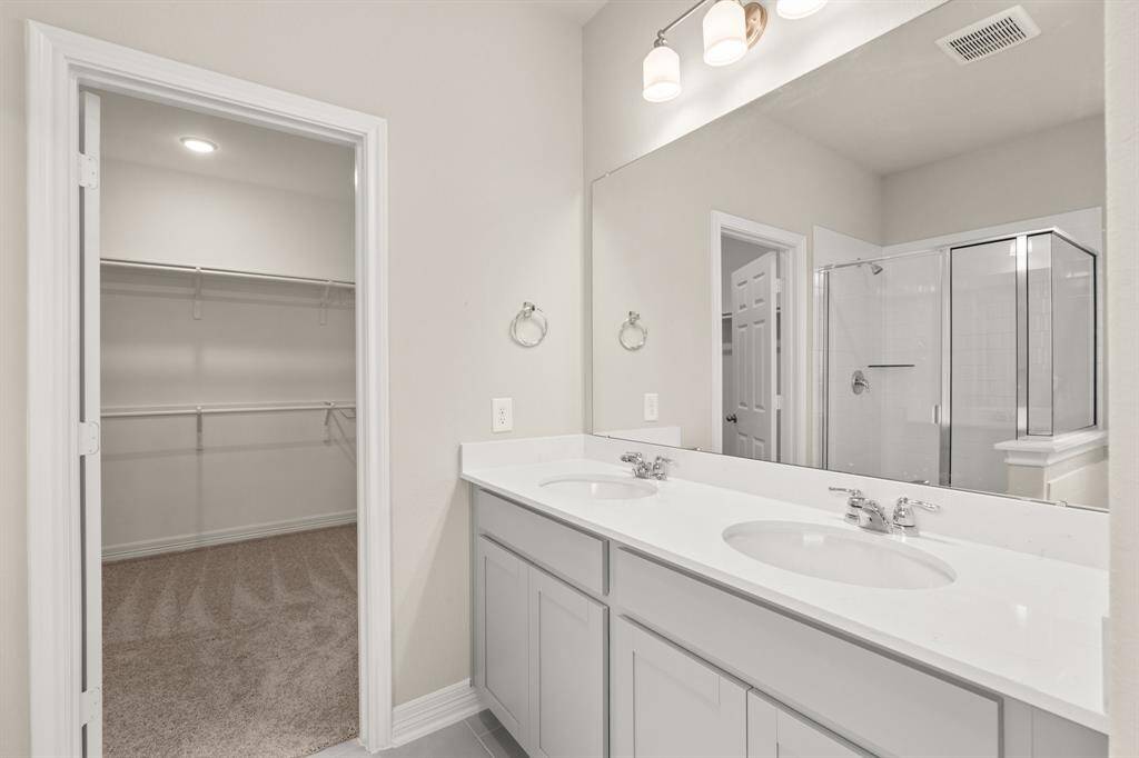 The en-suite bathroom offers a spa-like atmosphere with its elegant design, high end finishes, and tasteful lighting, creating a retreat within your own home.
