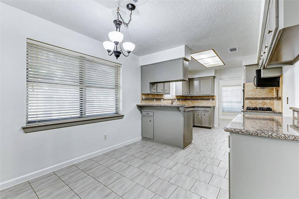 The breakfast room offers ample space for a table and chairs, making it the perfect spot for family meals or casual gatherings. Additional features include fresh paint, a charming chandelier overhead, and a large window that frames a view of the yard, letting natural light pour in and brighten the entire space.