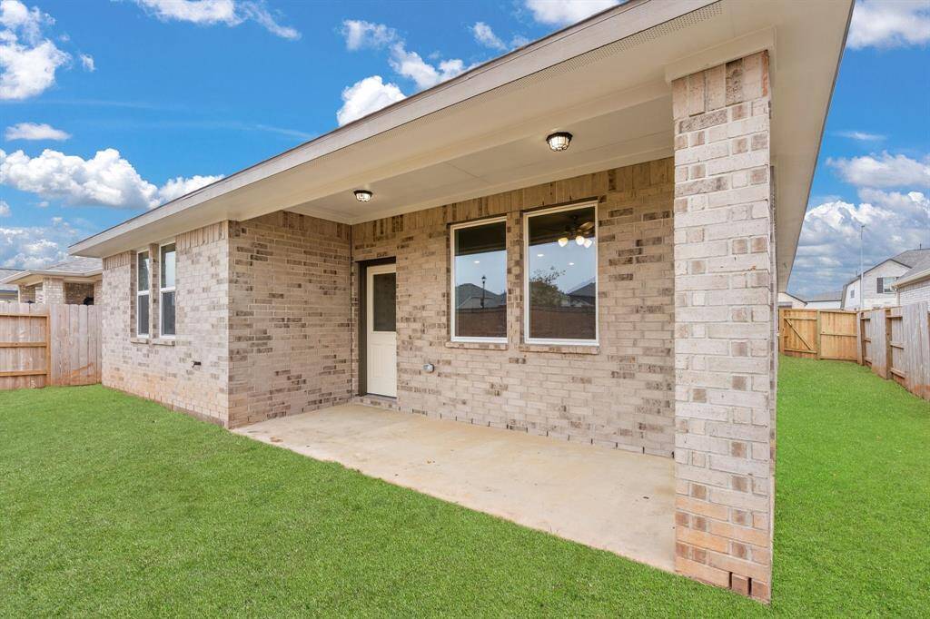 The covered patio is generously sized, providing ample space for various outdoor activities.