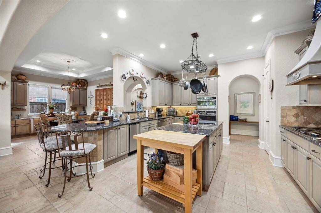 This beautiful kitchen features SS appliances including a GE Profile convection oven, GE Profile microwave, Sub-Zero refrigerator, ice maker, and gas cooktop.