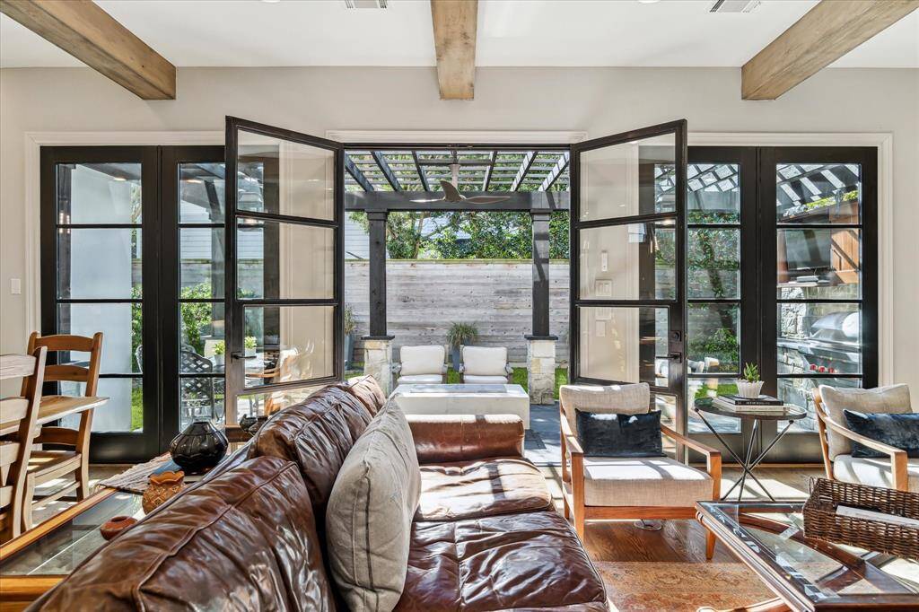 Iron doors open to a lovely outdoor living area with limestone detail, summer kitchen and fire table.