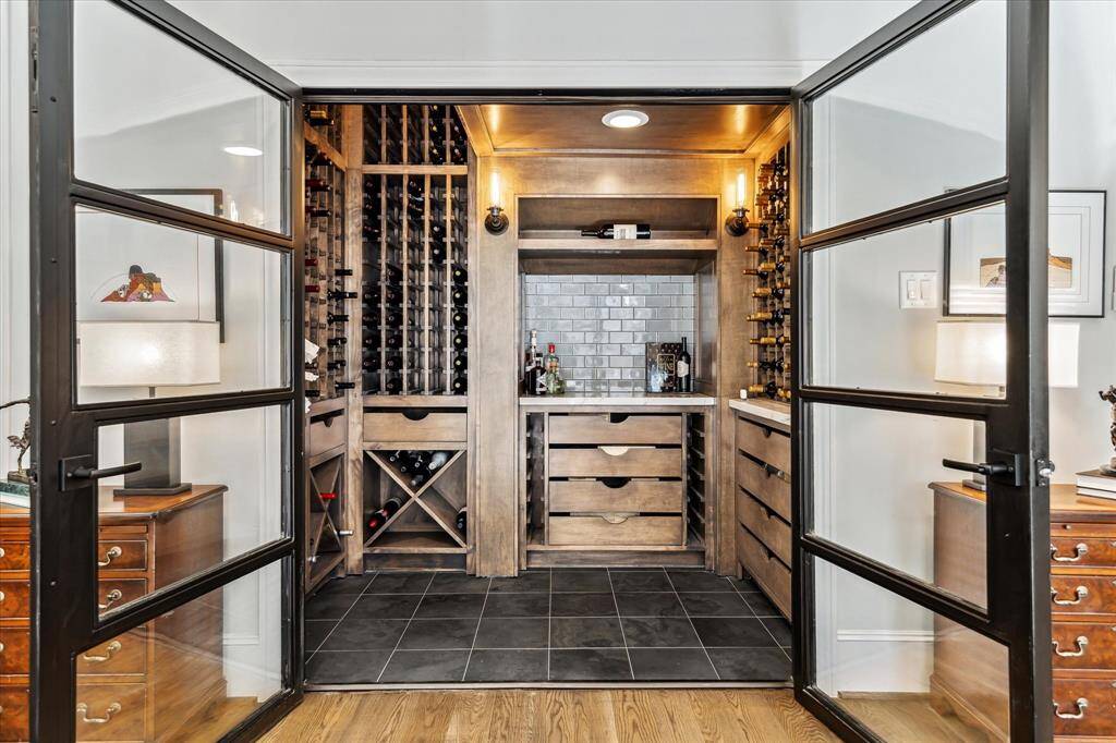 This wine room is a dream...it is temperature controlled with split A/C system and will hold more than 360 of your favorite wines. Step inside and you will see beautiful details: Giotto quartzite countertop, Montauk black slate floors, custom racks, and insulated glass doors opening to the Den. This is guaranteed to be a hit with family & friends.. what an amazing space.