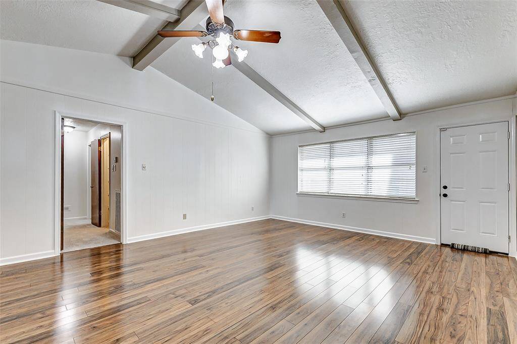 Natural light pours in through a large window, complete with blinds, offering a lovely view of the backyard while filling the room with warmth. The spacious layout also provides plenty of room for your large sectional or sofa, along with occasional chairs, creating an inviting space for relaxation and entertaining.