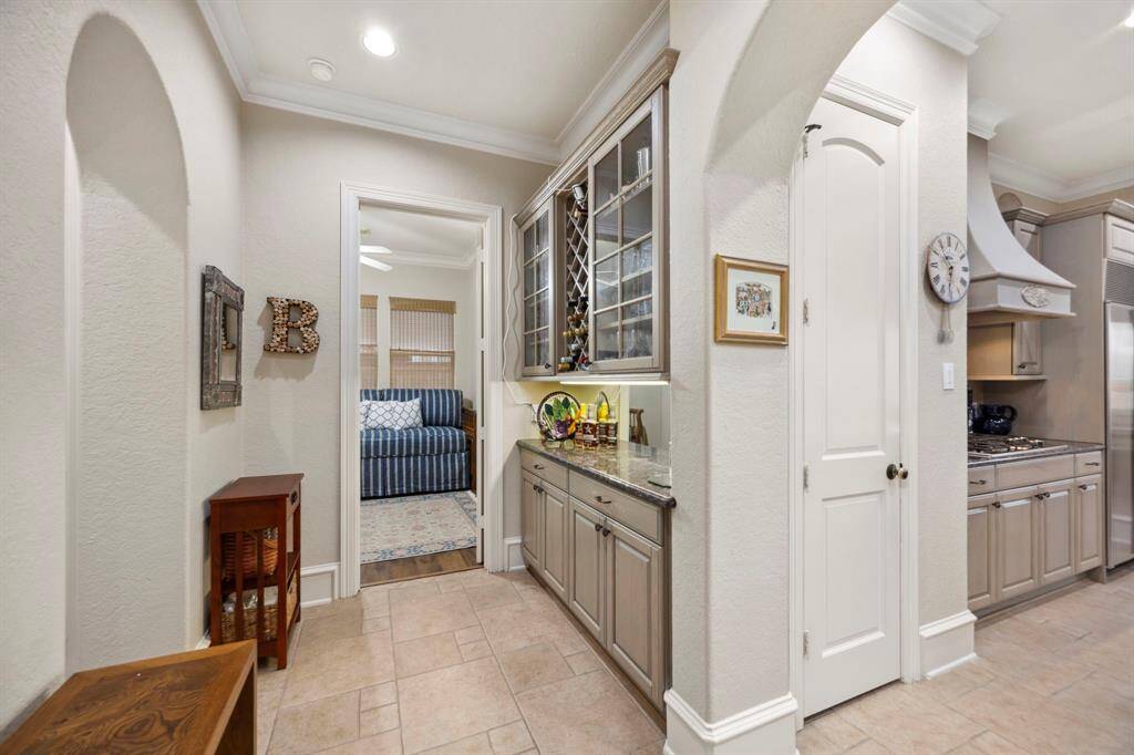 Just off of the kitchen is the butler's pantry and hallway leading to a secondary downstairs bedroom.