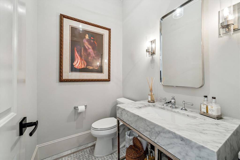 The Powder Bath is located off the main entry hall with Restoration Hardware marble vanity & lighting.