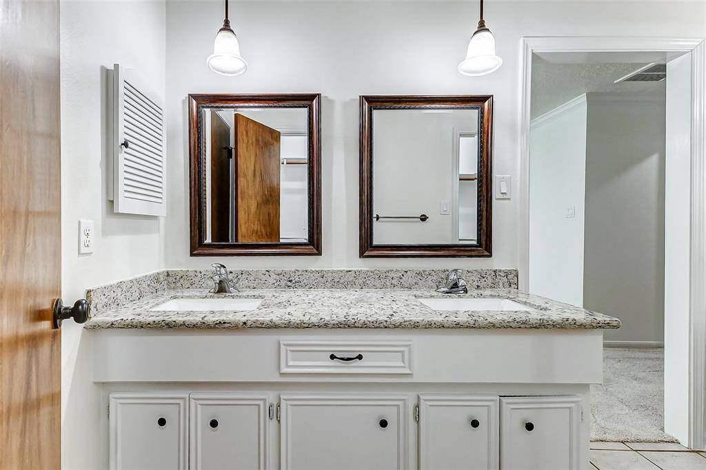 The recently installed commode and walk-in shower are thoughtfully tucked away behind a door, ensuring privacy, while the spacious walk-in closet is conveniently located across from the vanity for easy access.