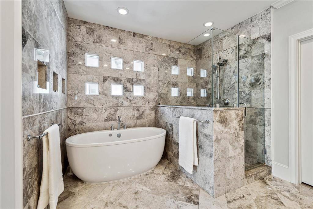 The Primary Bath is gorgeous and will pamper you with all the pretty features including Platinum quartzite vanity, silver marble flooring and wall, dual sinks, Kohler slipper bathtub and Restoration Hardware sconce lighting.