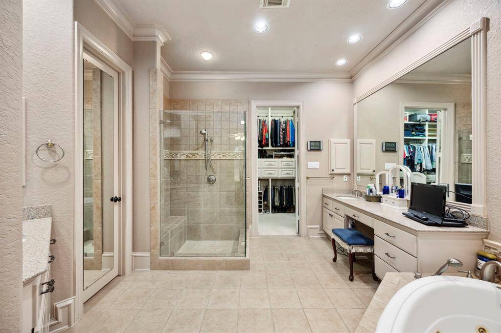 The beautifully updated master bath offers a frameless shower, separate tub & vanities, and a large walk in closet complete with built in storage.