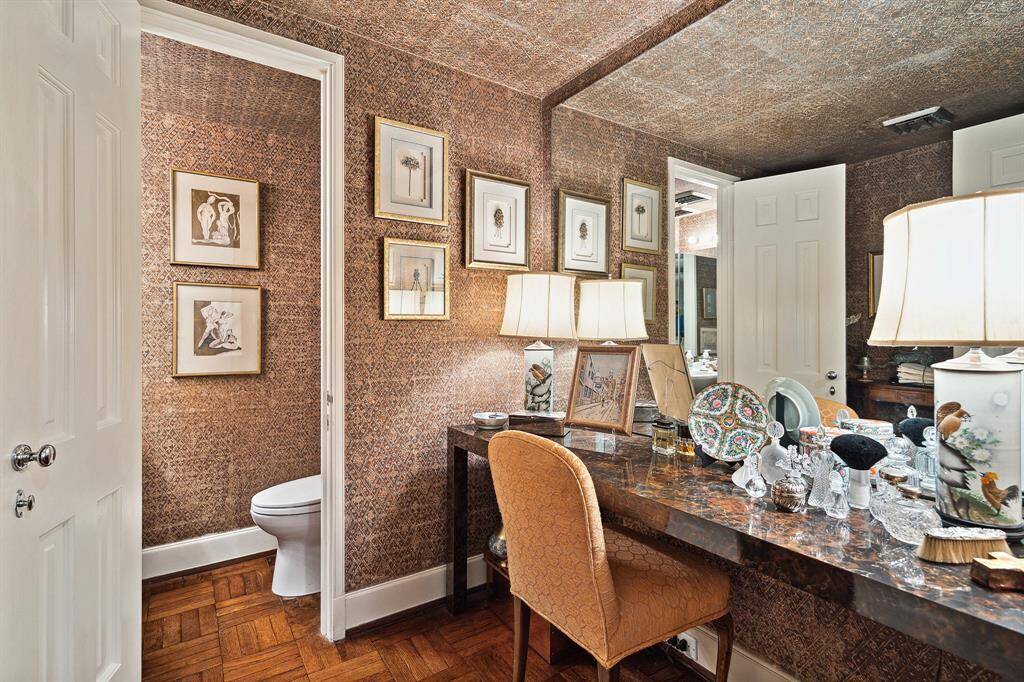 [Powder Room]Covered in elegant vintage gilded wallpaper, the powder room provides an elegant vanity cabinet and a water closet with pocket door.