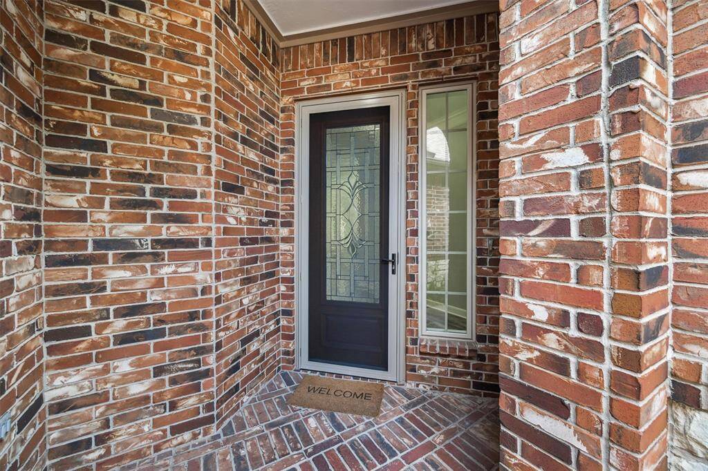 The striking brick exterior of this David Powers-built patio home boasts charming curb appeal, complemented by a cozy patio and a beveled glass door. An additional security door was also added.