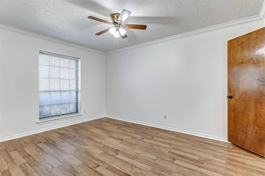 Designed with attention to detail, theadditional bedrooms all offer cozyretreats for family members orguests, each adorned with its uniquecharacter and style. This room has beautiful wood-look flooring and a ceiling fan overhead.