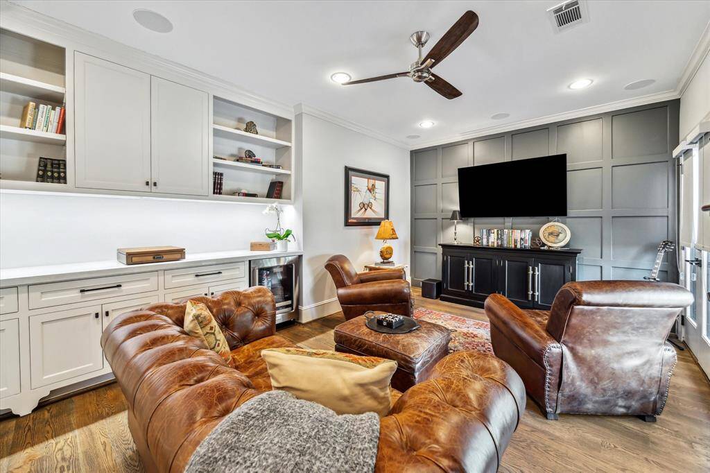 This wonderful gameroom faces north and enjoys great natural sunlight. The owners designed this room with French doors, white oak floors, wood paneled accent wall, custom cabinetry with quartz counters and an under-counter beverage chiller. There is even an attached office/study nook area. The gameroom is wired for Dolby surround sound.