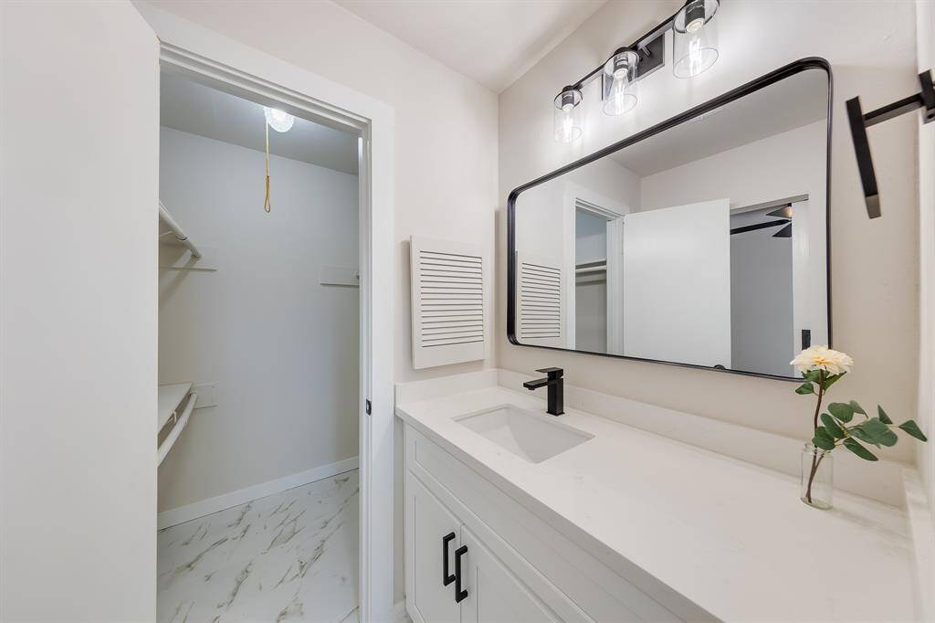 Primary sink with vanity space and see walk in closet.
