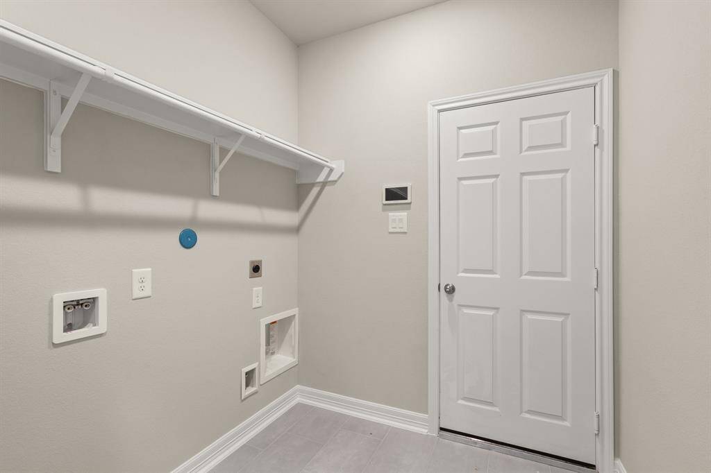 The laundry room layout is carefully planned for optimal workflow with designated areas for washing, drying, and storing.