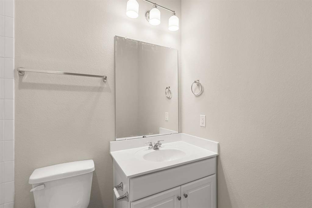 The secondary bath features tile flooring, white cabinetry and light countertops and a shower/tub combo. Perfect for accommodating any visiting family and friends.