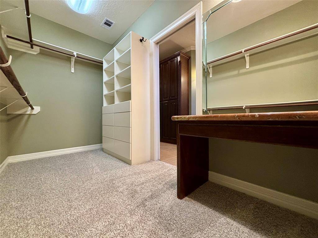 Custom built-ins are found in the master closet along with a vanity area complete with large wall mirror and lighting!