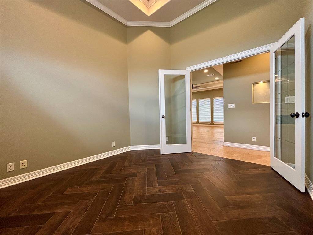 Office space located at the front of the home offers 2 large windows for plenty of light, tray ceiling, recessed lighting, double glass French doors and brand new wood-look tile flooring!