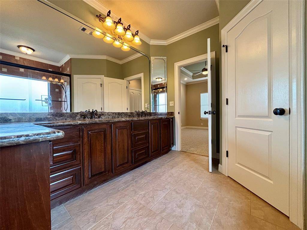Shared full bathroom that services 2nd and 3rd bedroom offers dual sinks, full wall to wall mirrors separate water closet and large tub/shower combo with elegant glass doors.
