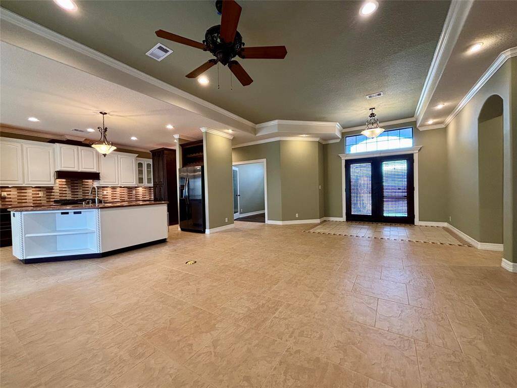 Grand entry and living area open to the kitchen. Custom recessed LED lighting in the ceiling, crown molding throughout the home and wide-open space to entertain or just spread out and enjoy luxury living!