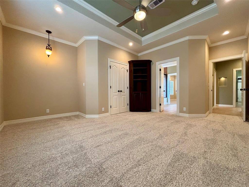 3rd bedroom that offers small reading nook or would-be desk space, custom corner built-in cabinet and the same elegant tray ceiling and crown molding as seen throughout the entire home.