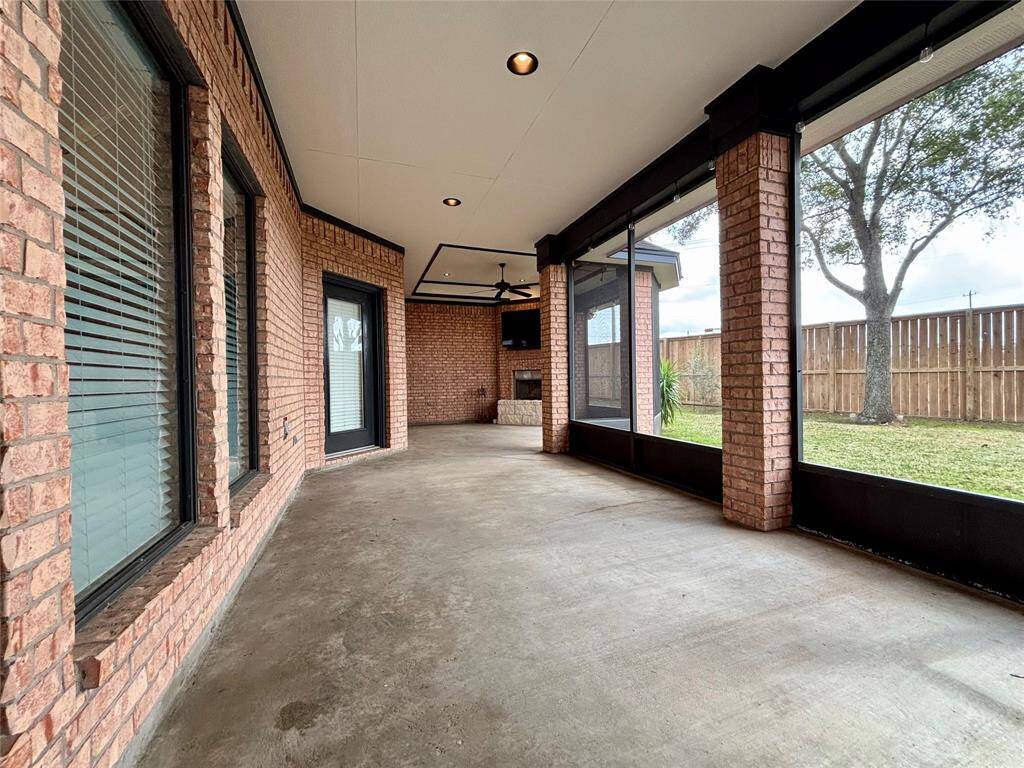 Expansive back patio with recessed lighting, fresh paint, pressure washed, fireplace, TV and patio string lighting.