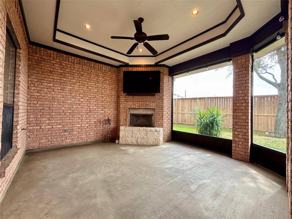 Incredibly huge back patio that has been pressure washed, re-painted and features custom tray ceiling with stone and brick gas fireplace, recessed lighting and external gas connection for grill! TV conveys!